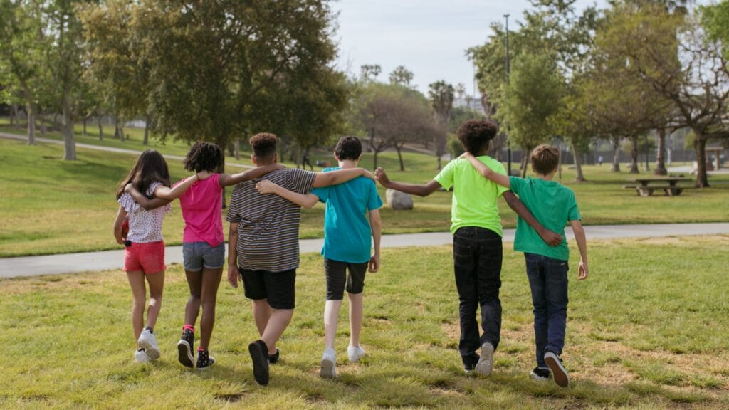 niños abrazándose paseando por un parque