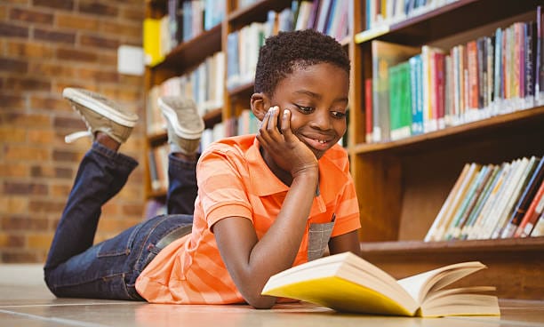 Un niño leyendo un libro en la biblioteca