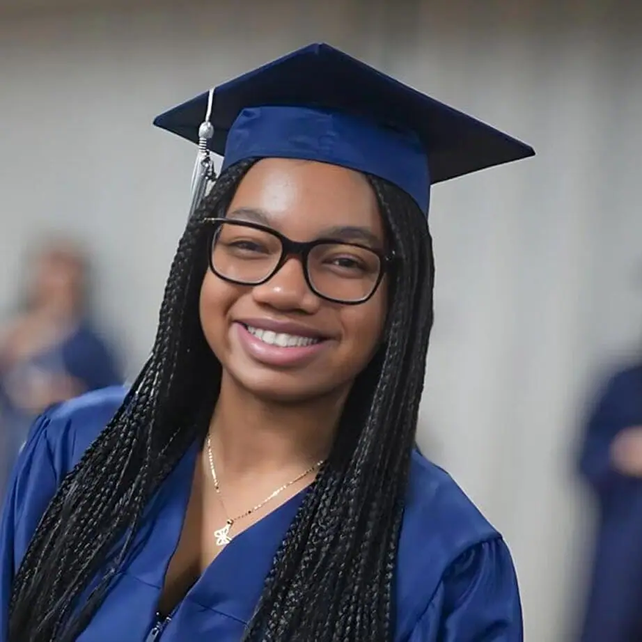 Estudiante graduado sonriendo a la cámara