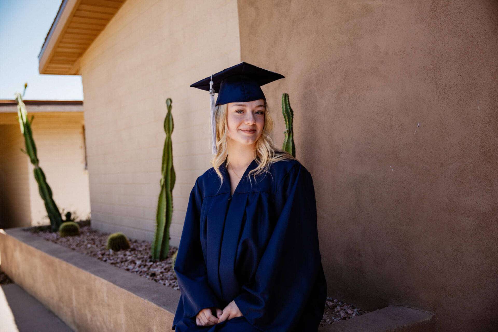 Brianna, una graduada de 16 años de la Academia Virtual de Arizona, sonríe con su toga y birrete.