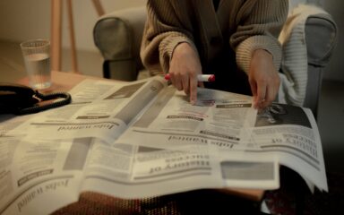 Persona leyendo y subrayando un periódico